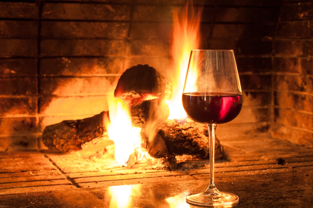 clear wine glass with red wine on brown wooden table