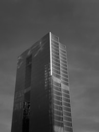 Elegant charcoal grey corporate building silhouette under a deep blue sky, reflecting strength and stability.