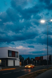 Stylized dark gray cityscape with a bright yellow car cruising through.