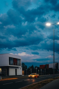Stylized dark gray cityscape with a bright yellow car cruising through.