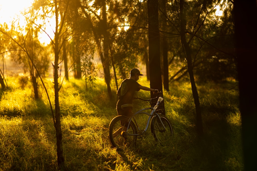 a man riding a bike through a lush green forest