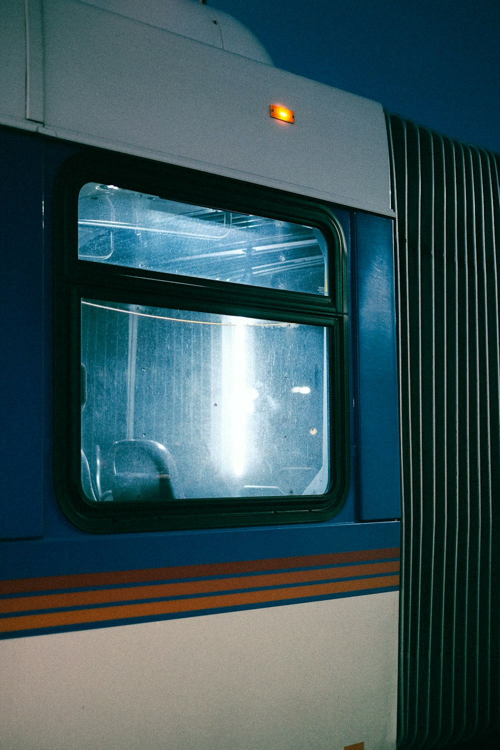 a blue and white train car with a window