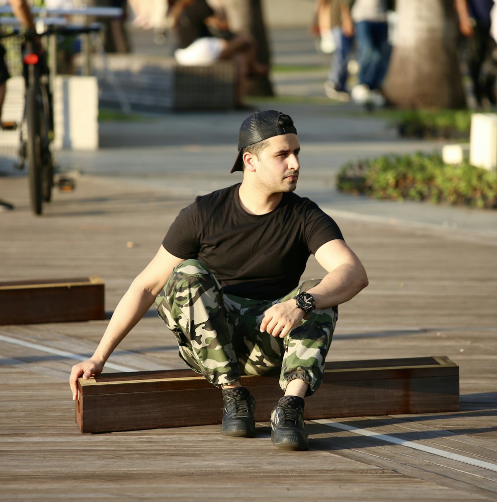 a man sitting on a wooden bench in a park