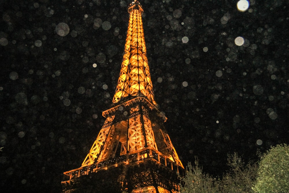 the eiffel tower is lit up at night