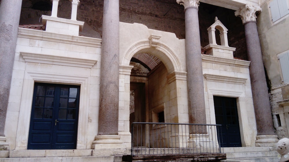 ein altes Gebäude mit Säulen und einer blauen Tür