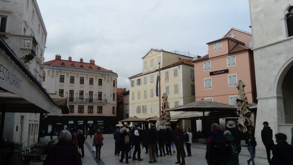 a crowd of people walking around a city square