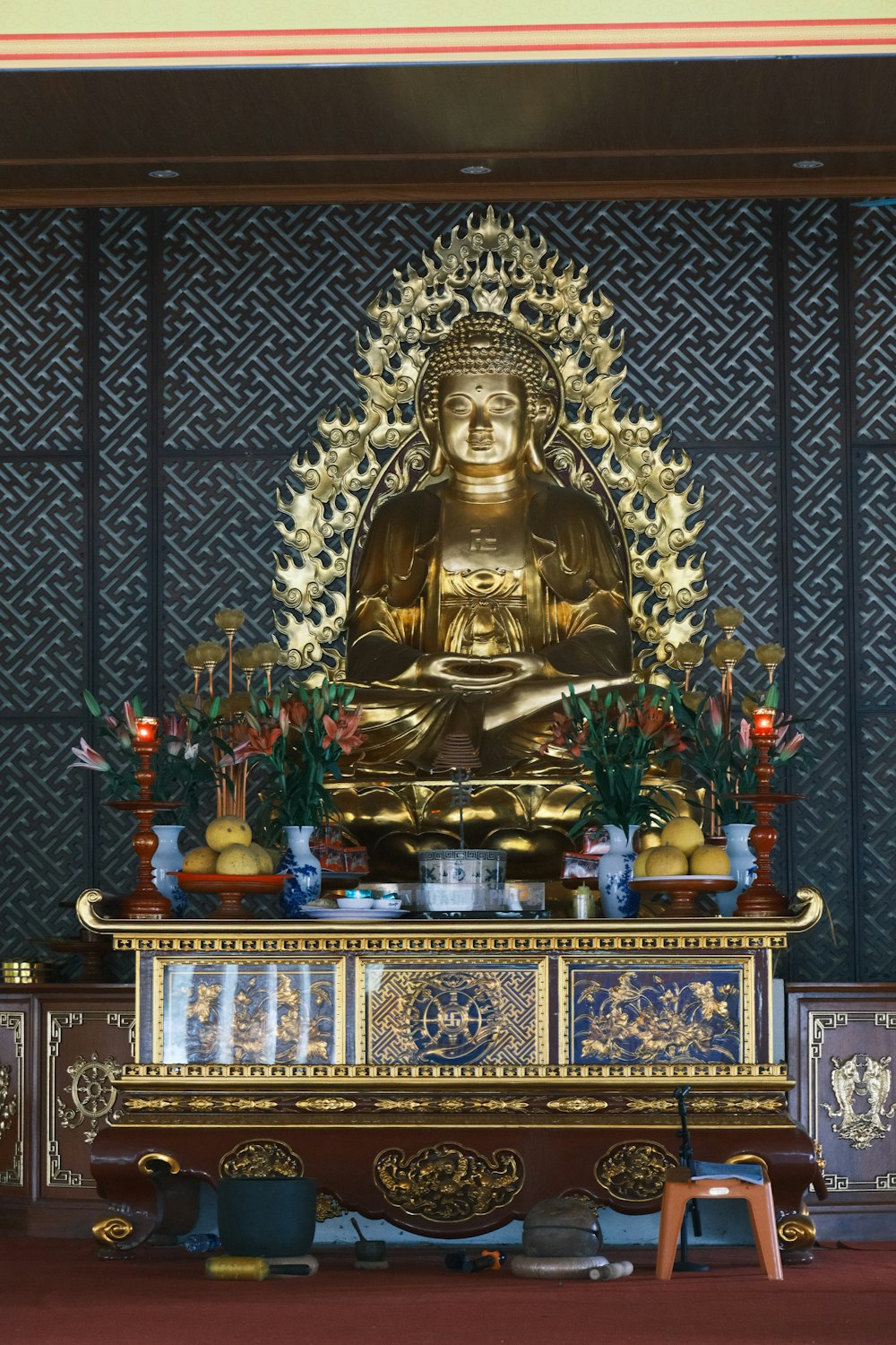 a golden buddha statue sitting on top of a wooden table