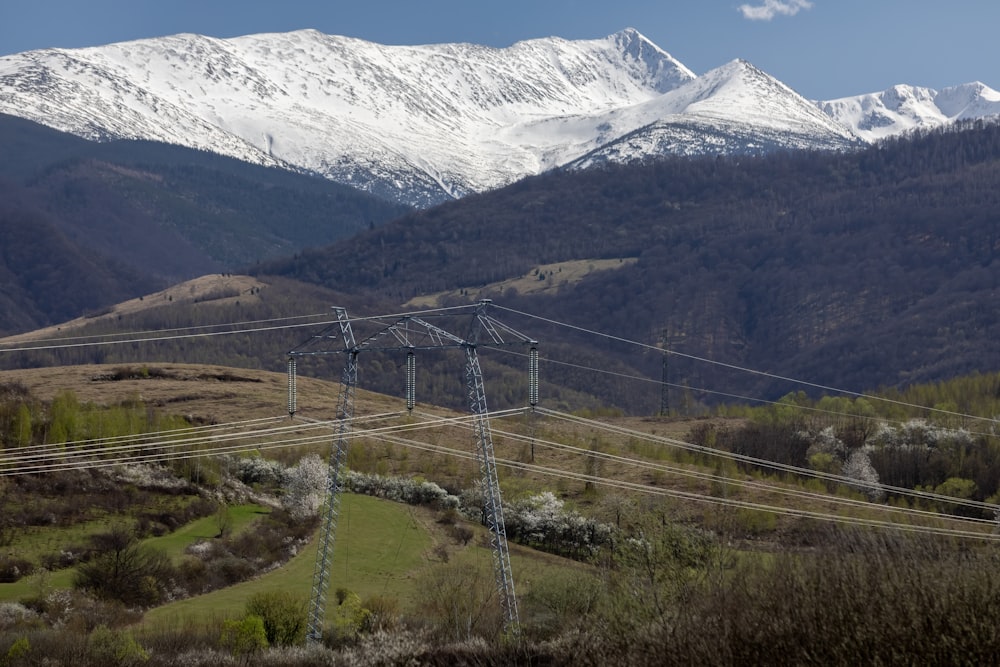 Una veduta di una catena montuosa con linee elettriche in primo piano