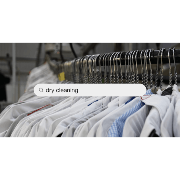 Administrator at dry cleaners keeps clean clothes on hangers in bag, Stock  image