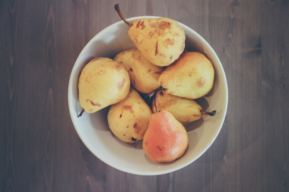 flat lay photography of bowl of ripe pear fruits