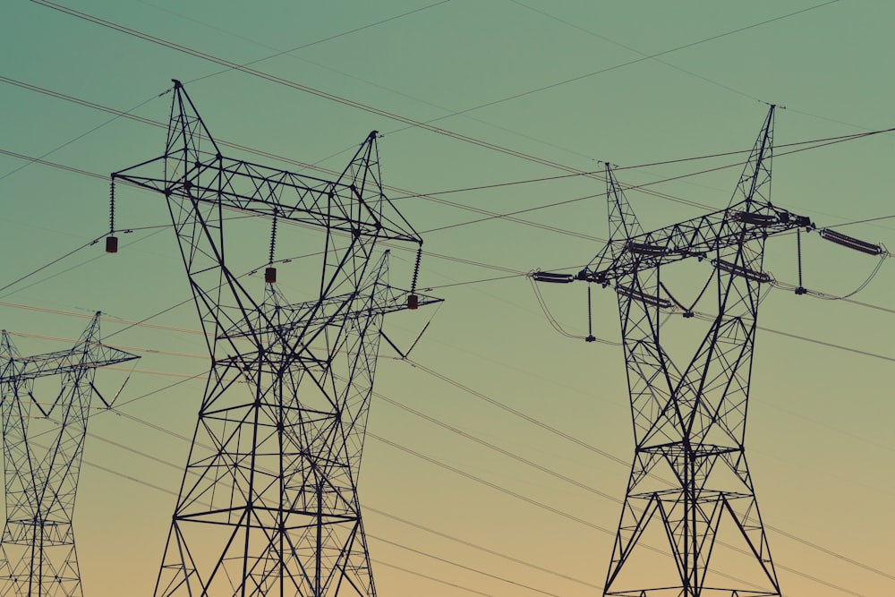 black transmission towers under green sky