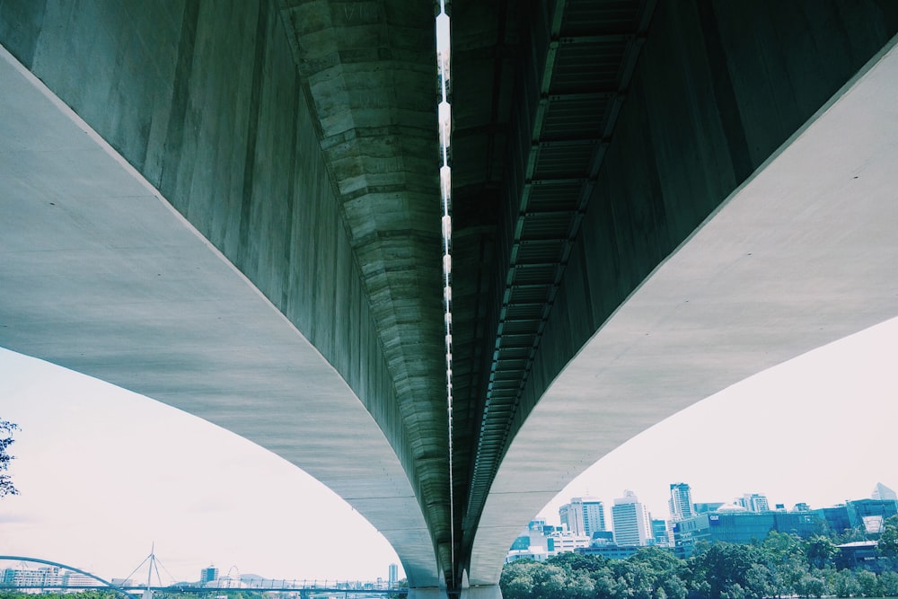 low angle photo of gray concrete bridge