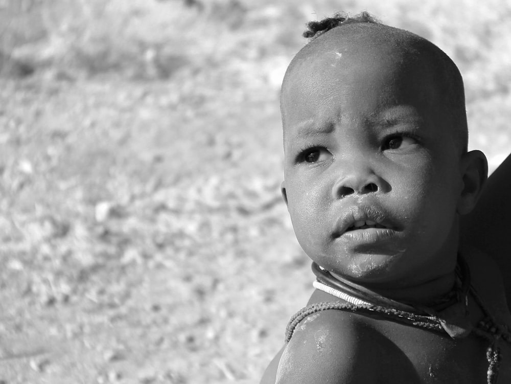 grayscale photo of person carrying child