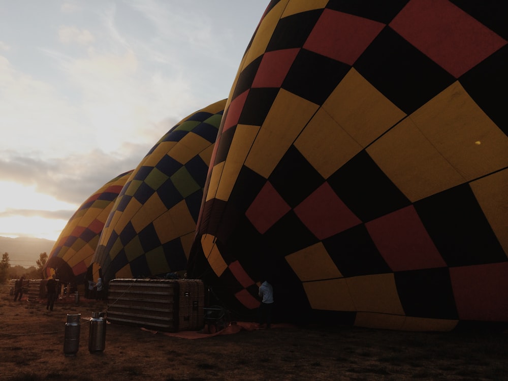 Drei aufgeblasene bunte Heißluftballons auf dem Feld