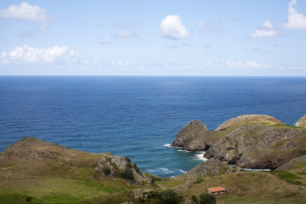 Casa branca e laranja perto do penhasco e do oceano durante o dia