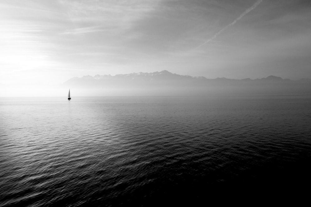 Segelboot auf ruhigem Gewässer unter weißem Himmel bei Tag