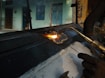 person welding black metal part