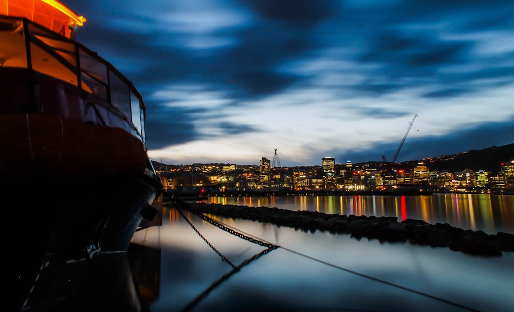 a boat docked at a dock with a city in the background