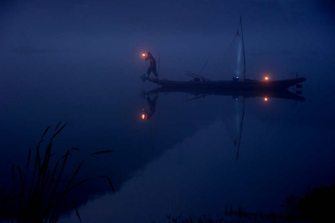 person on boat holding lantern