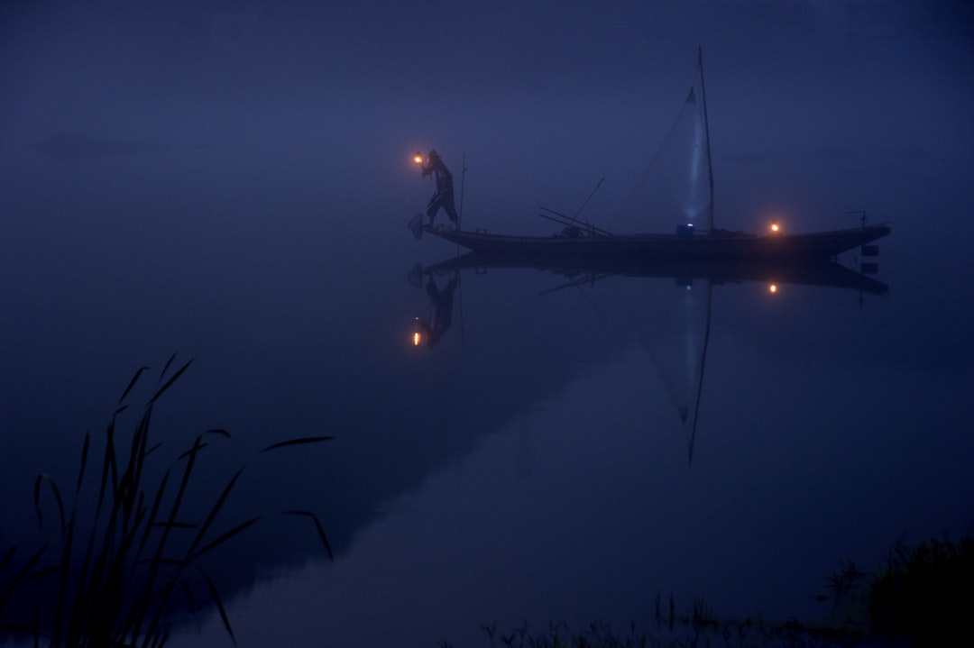 person on boat holding lantern, Man Boat Dark Lake