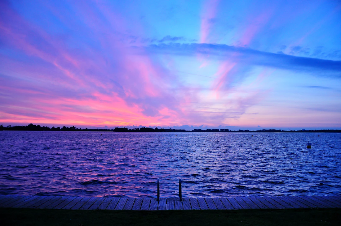 Pink and purple sunset over open lake water
