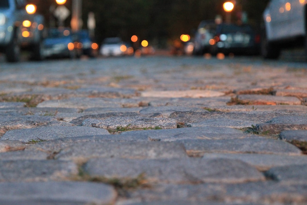 water droplets on gray concrete pavement during night time