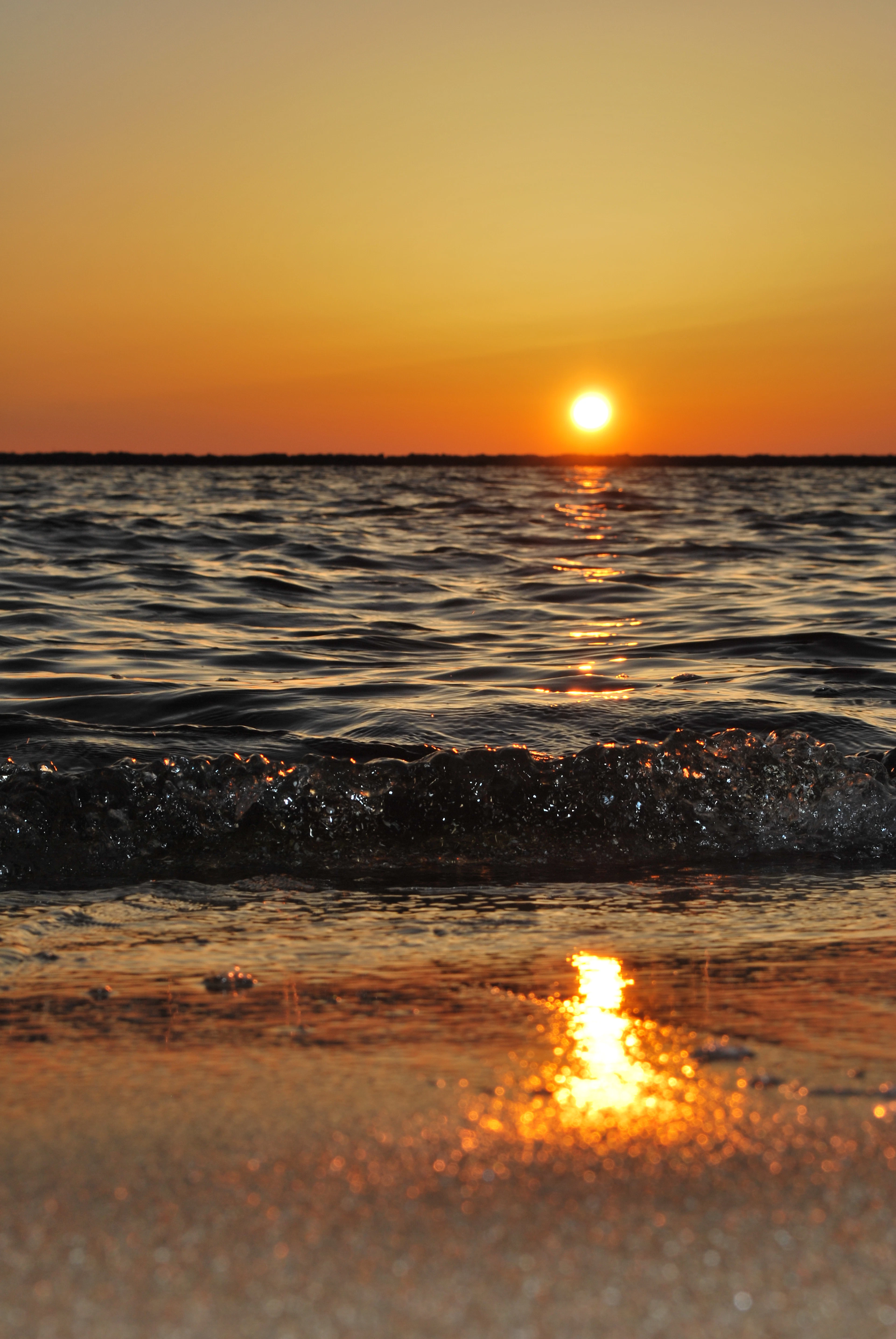 The sun setting low over the open sea