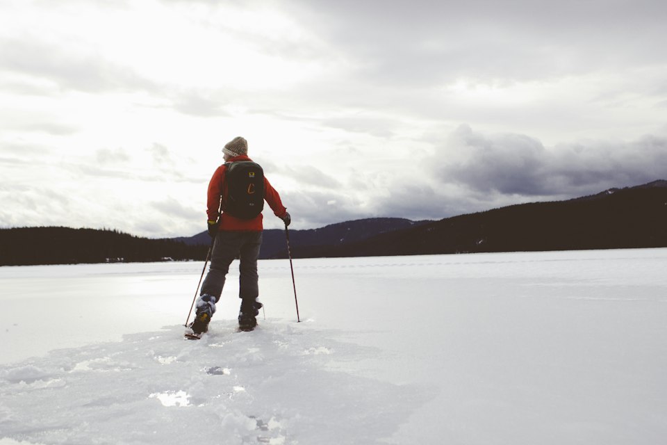 A cross-country skier crossing an open snowy valley