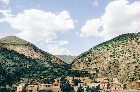 A scenic view of Albanian mountains with houses nestled among greenery.