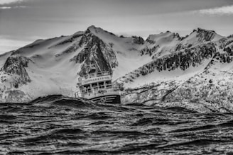 A rugged saltwater fishing boat cutting through choppy ocean waves at dawn.