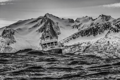 A rugged saltwater fishing boat cutting through choppy ocean waves at dawn.