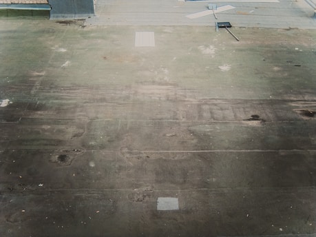 A house roof mid-cleaning, showing a clear contrast between cleaned and uncleaned areas.