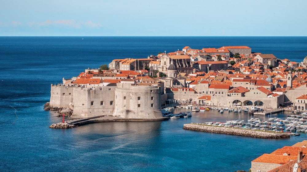 white and red concrete houses beside sea