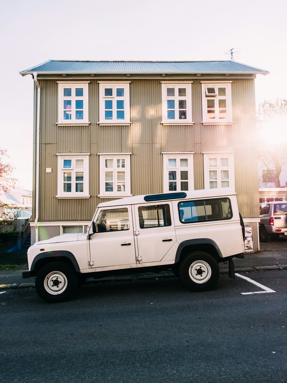 white vehicle near beige house