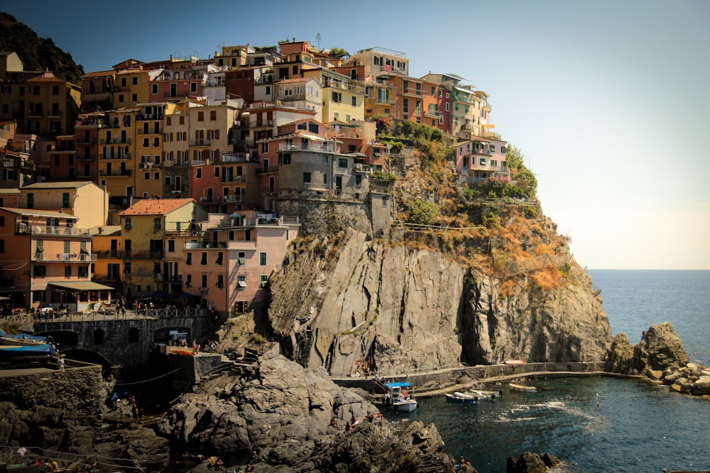 houses on cliff beside ocean during daytime