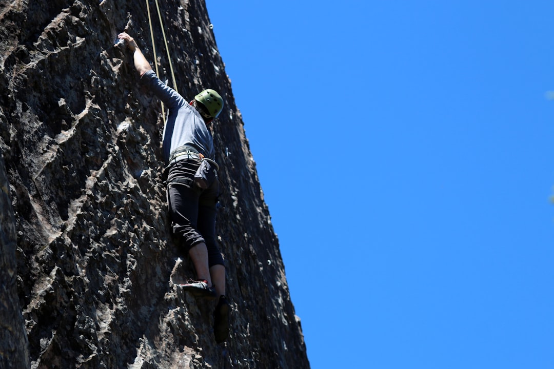 man performing wall climbing under clear sky, Man rock climbing