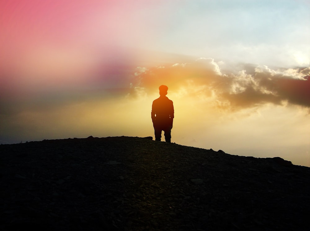 silhouette of person standing on hill