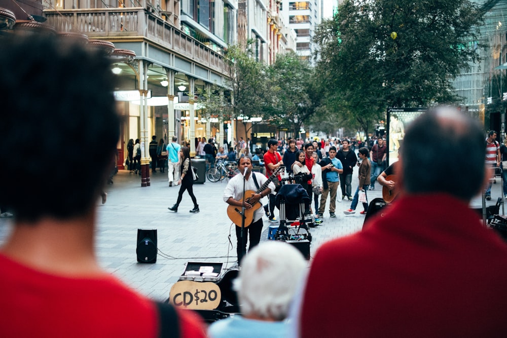 homme jouant de la guitare tout en chantant