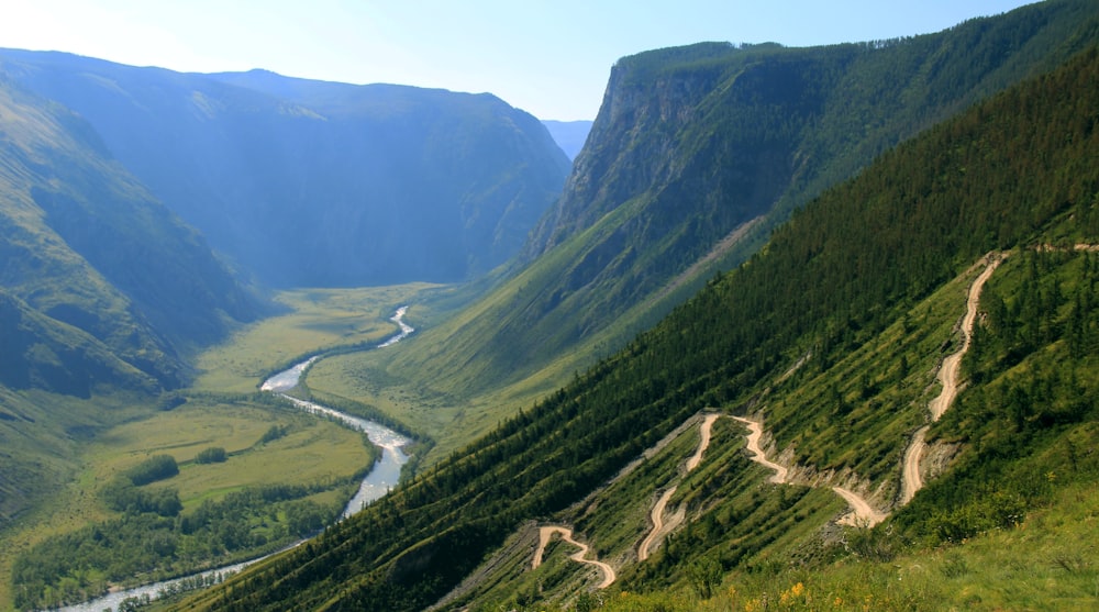 aerial photography of river between green mountains