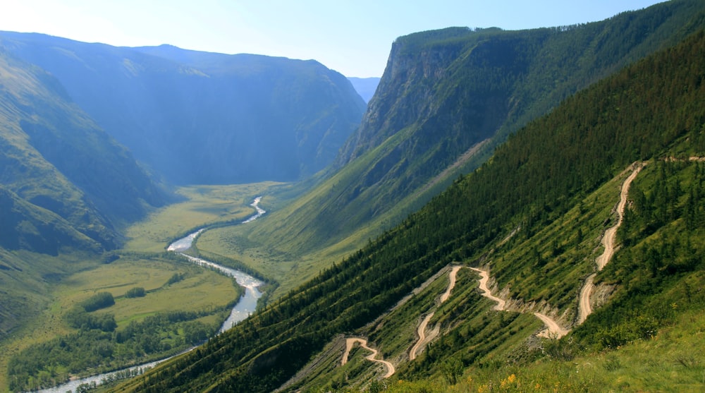 Photographie aérienne d’une rivière entre les montagnes vertes
