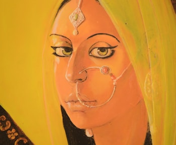 A stylized painting of a person with distinct makeup, featuring pronounced eyes and a facial jewelry piece. The artwork has a yellow-green background, and the individual has accessories like a traditional nose ring and head ornament.