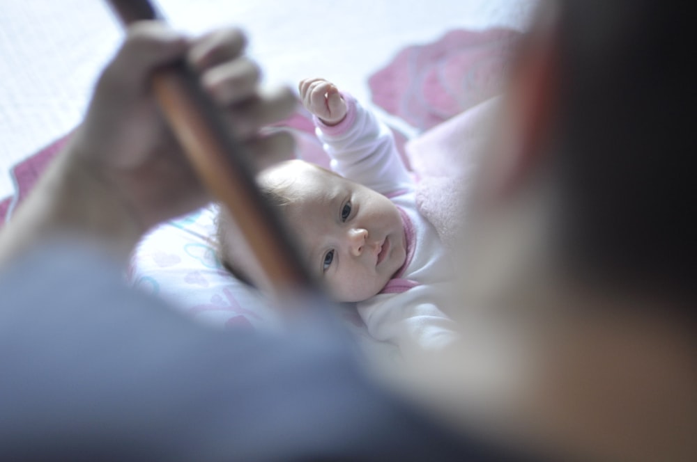 toddler lying on bed with comforter