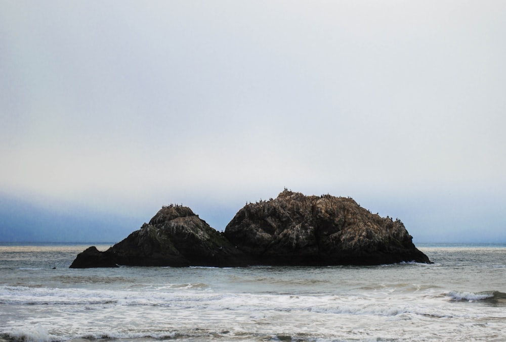 brown rock formation on body of water