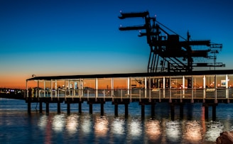 black wooden dock on body of water during sunset