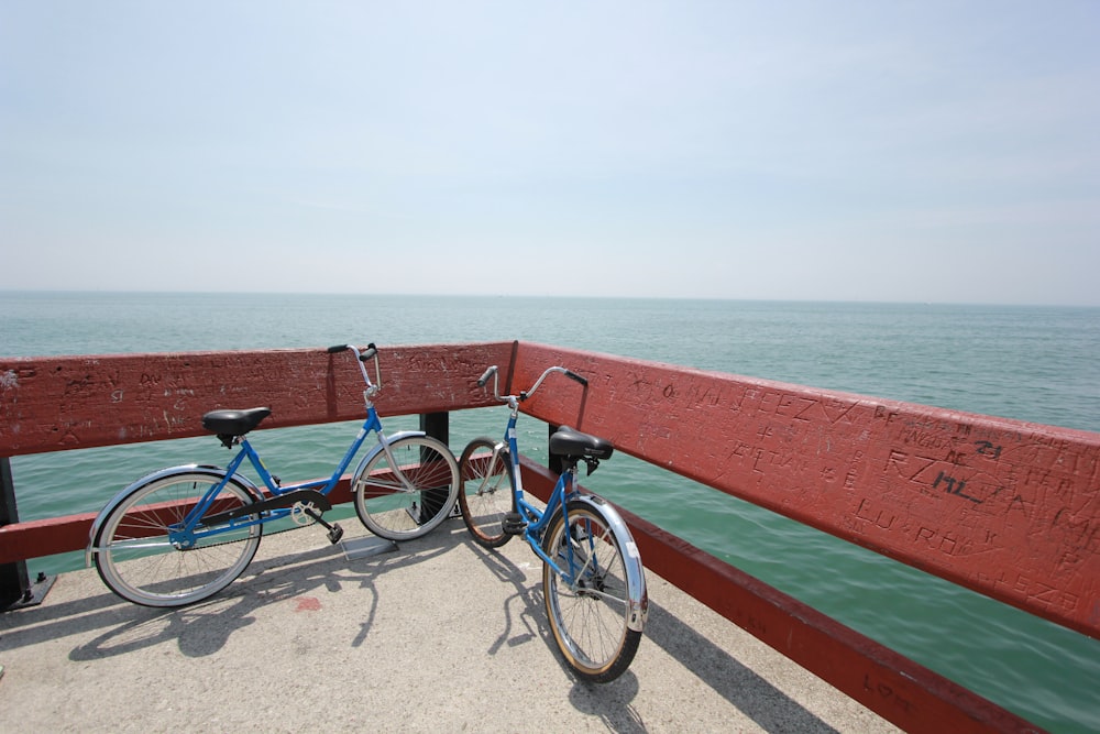 two bicycle parked beside red raiols