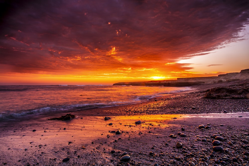 Specchio d'acqua sotto la foto del cielo rosso