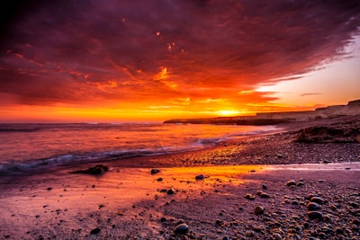 body of water under red sky photo stunning teams background