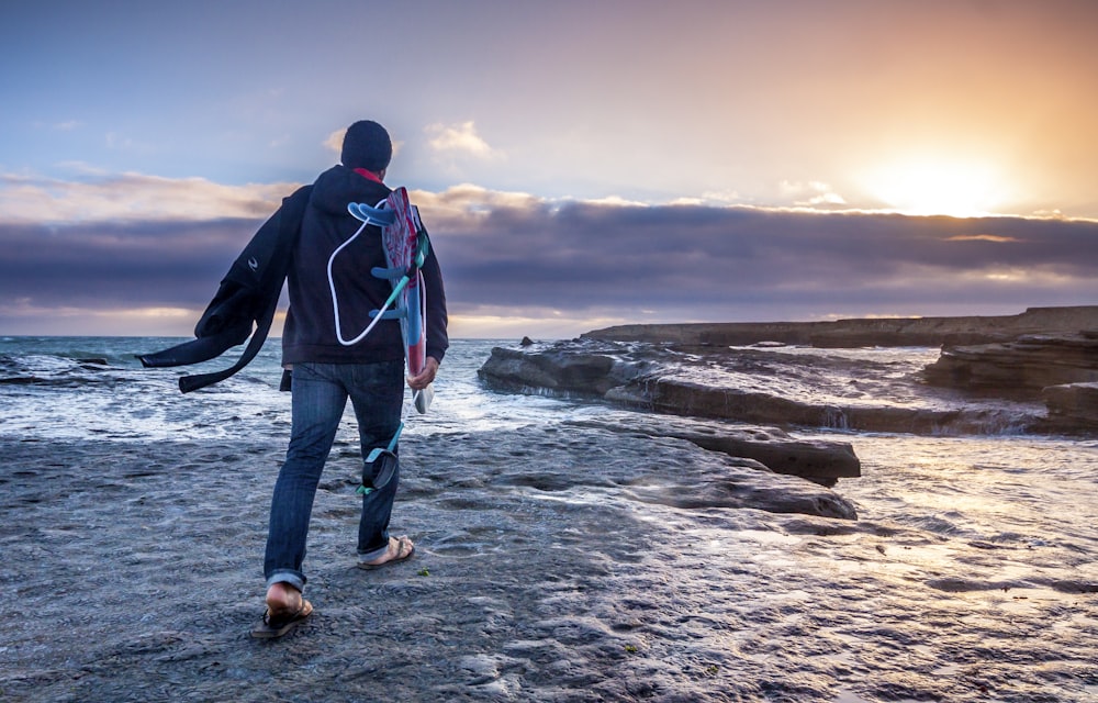 man in blue jeans walking on gray soil