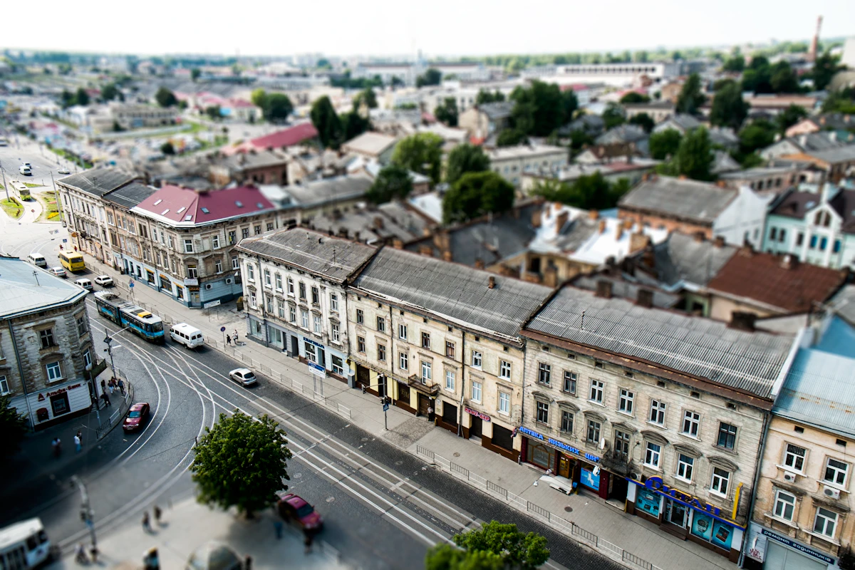 A high angle view of cars driving on a road between buildings