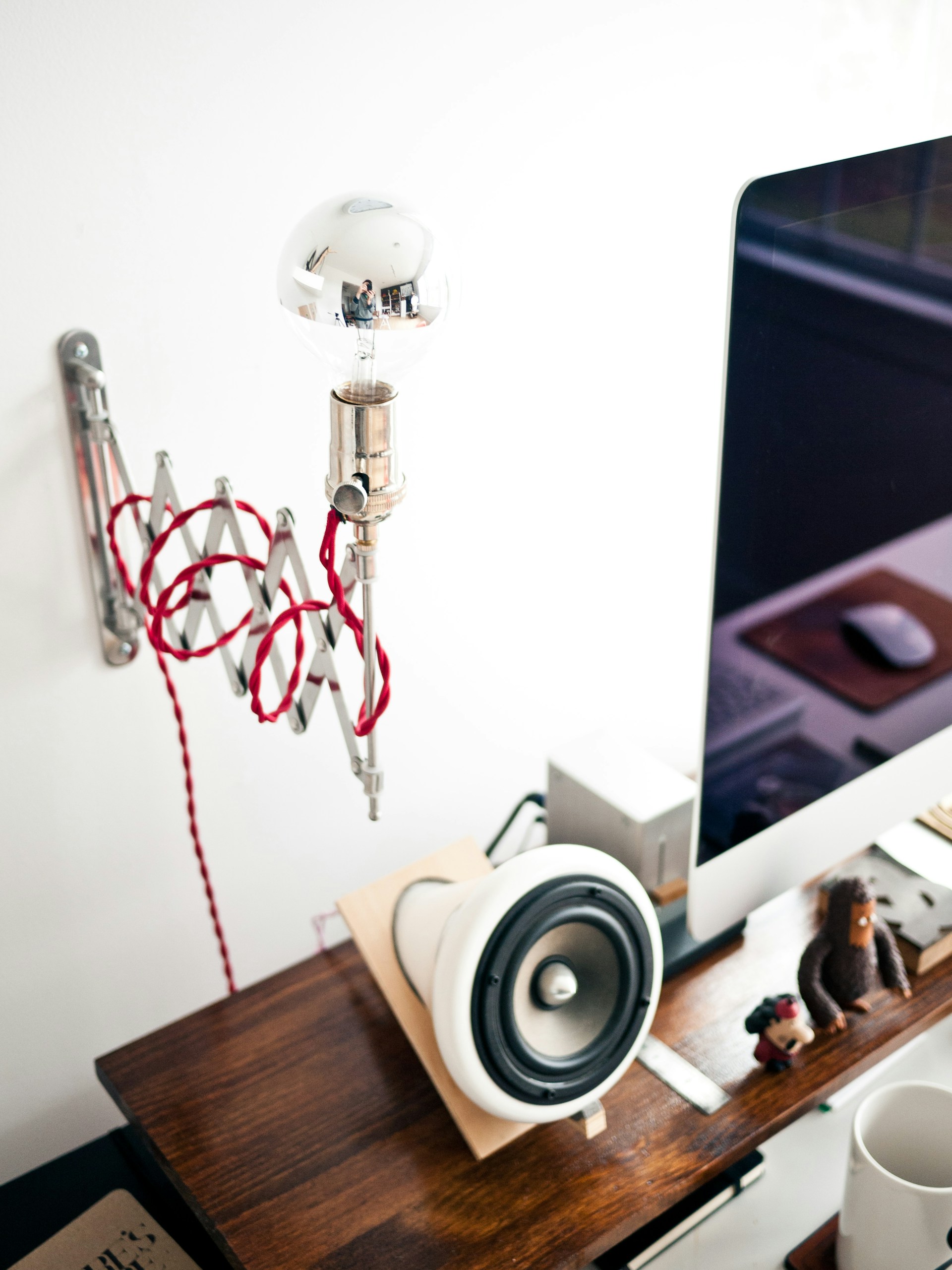 A clean, minimalistic desk setup featuring a projector casting a presentation on a white wall.